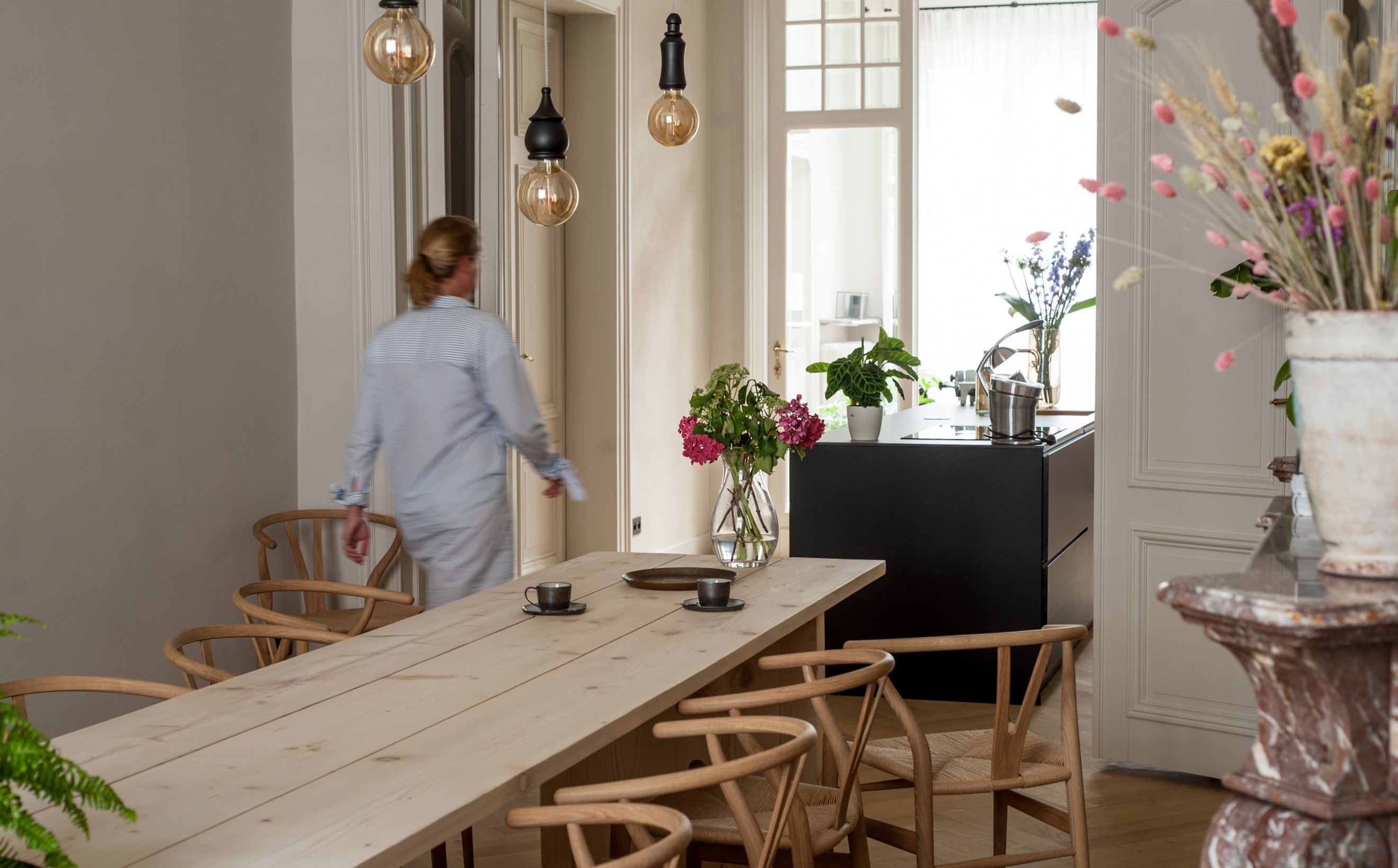 Stijvol, hedendaags tafelen, zittend op de CH24 Wishbone chair  Victors Design Agency